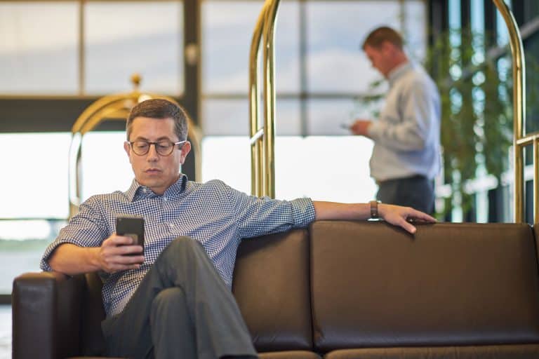 Man on phone sitting on couch inside Cerulean FBO Building
